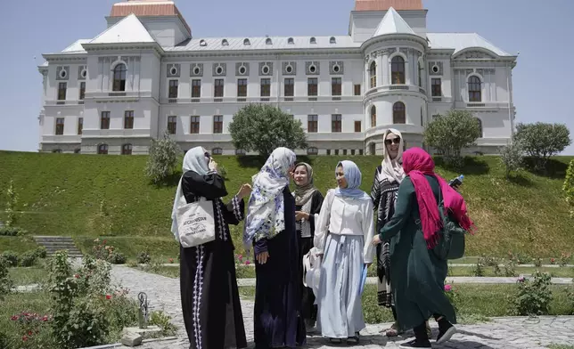 Three foreign, female tourists, two at right, and second from left, visit Darul Aman Palace accompanied by three female tour guides in Kabul, Afghanistan, Wednesday, May 28, 2025. (AP Photo/Ebrahim Noroozi)