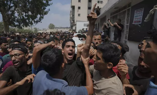 Palestinians carry the bodies of people who were killed in an Israeli airstrike on a school in Gaza that has been used as a shelter, during their funeral near the Al Shifa Hospital in Gaza City, Friday, July 25, 2025. (AP Photo/Abdel Kareem Hana)