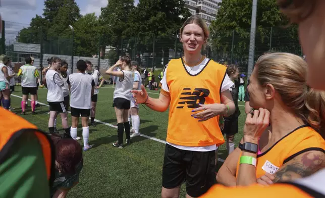 Billie Sky, center, a 28-year-old transgender player for Goal Diggers FC, a women and nonbinary inclusive soccer club, gestures while giving a team talk during a six a side soccer tournament in London, Sunday, June 1, 2025. (AP Photo/Alastair Grant)
