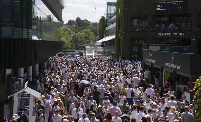 Spectators arrive for the Wimbledon Tennis Championships in London, Monday, June 30, 2025. (AP Photo/Kin Cheung)