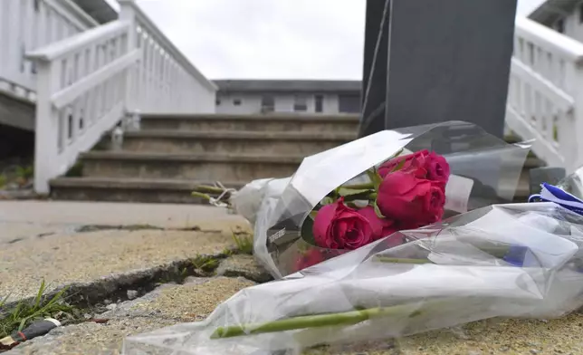 Flowers rest near an entrance to the Gabriel House assisted living facility, Monday, July 14, 2025, following a fire that started late Sunday and resulted in multiple fatalities, in Fall River, Mass. (AP Photo/Steven Senne)