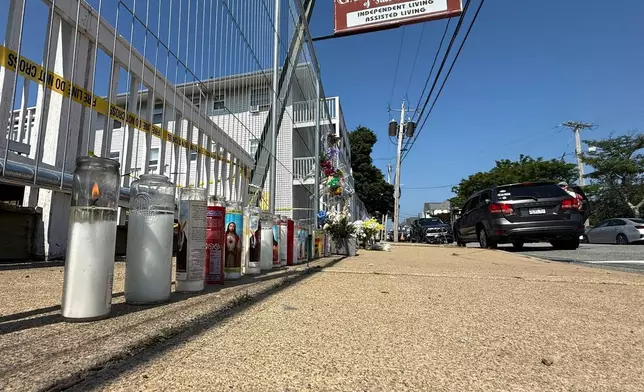 Flowers sit at a makeshift memorial in front of the Gabriel House assisted living facility, where a fire on Sunday killed several people, Wednesday, July 16, 2025 in Fall River, Mass. (AP Photo/Rodrique Ngowi)