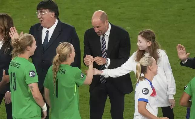 Britain's Prince William congratulates to England goalkeeper Hannah Hampton after the Women's Euro 2025 final soccer match between England and Spain at St. Jakob-Park in Basel, Switzerland, Sunday, July 27, 2025. (AP Photo/Michael Probst)