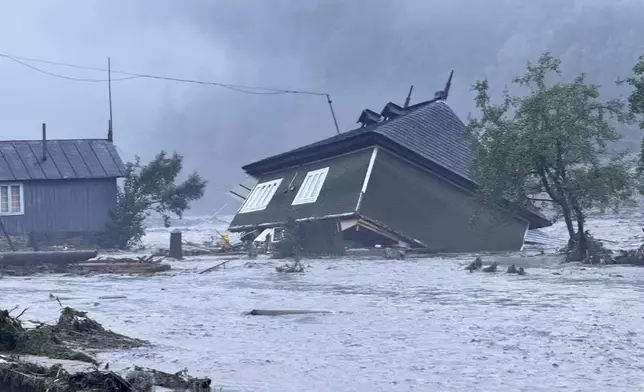 In this image released by the Romanian Emergency Services Suceava (ISU Suceava) a house is damaged after a flash flood in the village of Brosteni, northern Romania, Monday, July 28, 2025. (Romanian Emergency Services - ISU Suceava via AP)