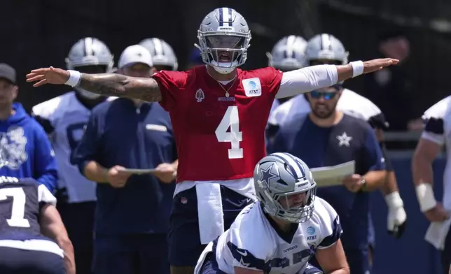 Dallas Cowboys quarterback Dak Prescott, top, gestures as he stand behind center Brock Hoffman during training camp Tuesday, July 22, 2025, in Oxnard, Calif. (AP Photo/Mark J. Terrill)