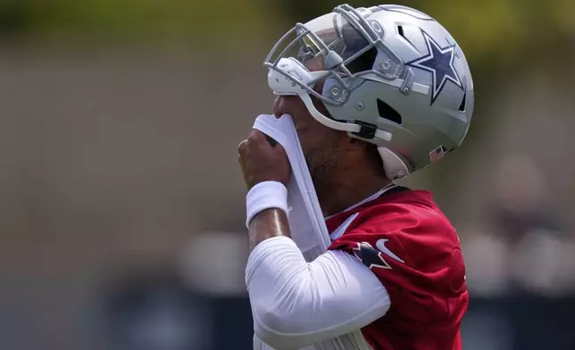 Dallas Cowboys quarterback Dak Prescott wipes his face during training camp Tuesday, July 22, 2025, in Oxnard, Calif. (AP Photo/Mark J. Terrill)