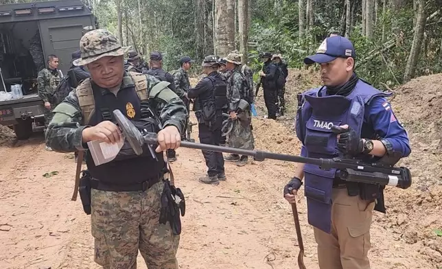In this Sunday, July, 2025, photo released by the Royal Thai Army, Thai soldiers inspect a border area in Ubon Ratchathani†province where the Royal Thai Army said two anti-personnel landmines were found. (Royal Thai Army via AP)