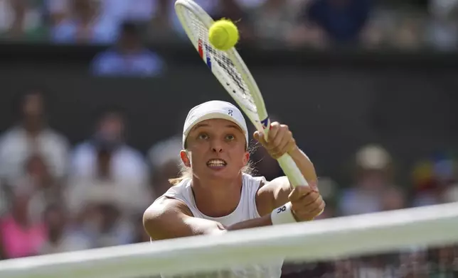 Poland's Iga Swiatek returns to Amanda Anisimova of the U.S. during the women's singles final at the Wimbledon Tennis Championships in London, Saturday, July 12, 2025. (AP Photo/Kin Cheung)