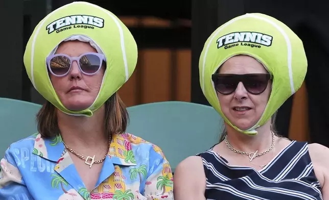 Members in the crowd wear a tennis ball hat as they watch Joe Salisbury of Britain and Luisa Stefani of Brazil during the mixed doubles final match against Sem Verbeek of Netherland and Katerina Siniakova of Czech Republic at the Wimbledon Tennis Championships in London, Thursday, July 10, 2025.(AP Photo/Kirsty Wigglesworth)