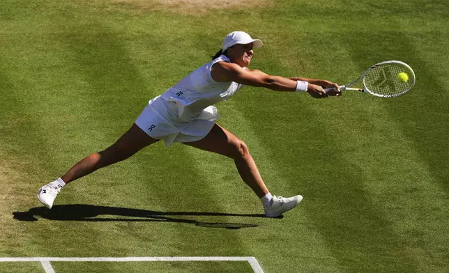 Iga Swiatek of Poland returns to Amanda Anisimova of the U.S. during the women's singles final match at the Wimbledon Tennis Championships in London, Saturday, July 12, 2025.(AP Photo/Joanna Chan)