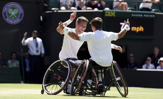 Martin de la Puente of Spain, right, and Ruben Spaargaren of the Netherlands celebrate after beating Alfie Hewett and Gordon Reid of Britain to win the final of the men’s wheelchair doubles at the Wimbledon Tennis Championships in London, Saturday, July 12, 2025. (Adam Davy/PA via AP)