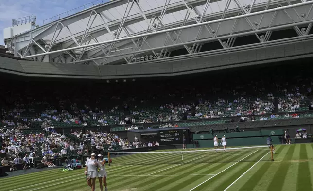 Su-Wei Hsieh of Taiwan, front right, and Latvia's Jelena Ostapenko Veronika Kudermetova confer between points as they play Elise Mertens of Belgium during the women's doubles final at the Wimbledon Tennis Championships in London, Sunday, July 13, 2025. (AP Photo/Kin Cheung)