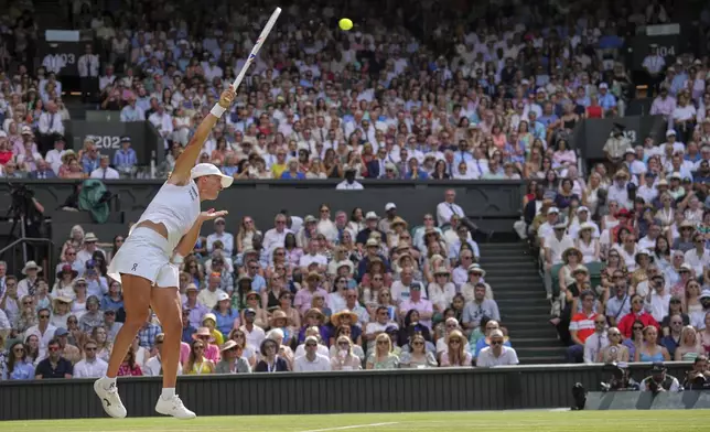 Poland's Iga Swiatek serves to Amanda Anisimova of the U.S. during the women's singles final at the Wimbledon Tennis Championships in London, Saturday, July 12, 2025. (AP Photo/Kin Cheung)