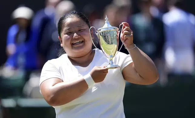 Wang Ziying of China celebrates with the trophy after beating Yui Kamiji of Japan to win the final women's wheelchair singles match at the Wimbledon Tennis Championships in London, Saturday, July 12, 2025. (John Walton/PA via AP)