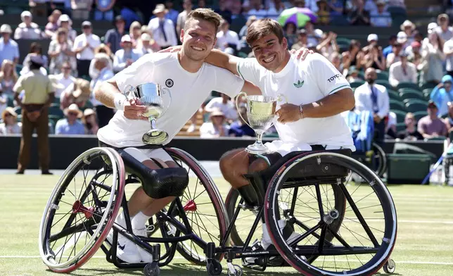 Martin de la Puente of Spain, right, and Ruben Spaargaren of the Netherlands celebrate with their trophies after beating Alfie Hewett and Gordon Reid of Britain to win the final of the men’s wheelchair doubles at the Wimbledon Tennis Championships in London, Saturday, July 12, 2025. (Adam Davy/PA via AP)