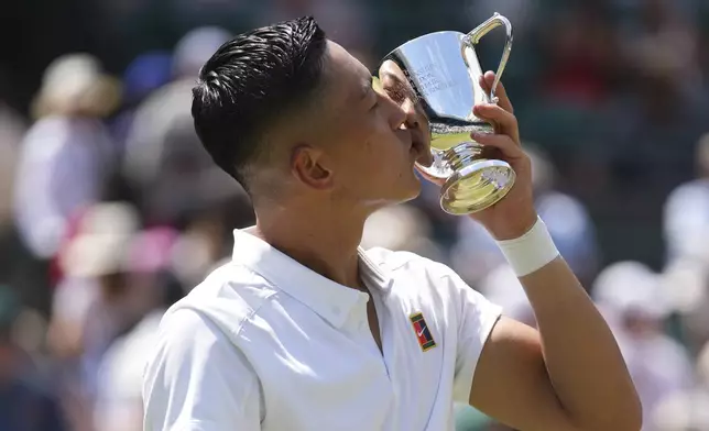 Tokito Oda of Japan kisses the trophy after winning the men's wheelchair singles final match against and Alfie Hewett of Britain at the Wimbledon Tennis Championships in London, Sunday, July 13, 2025.(AP Photo/Joanna Chan)