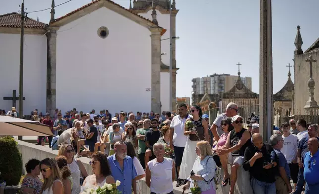 People gather at the church where the bodies of Liverpool forward Diogo Jota and André Silva have been brought for a wake and funeral in Gondomar, near Porto, Portugal, on Friday, July 4, 2025. (AP Photo/Manu Fernandez)
