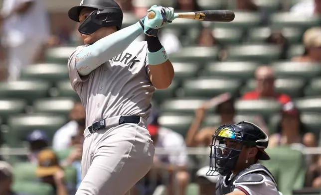 New York Yankees' Aaron Judge (99) hits a solo home run against the Atlanta Braves in the first inning of a baseball game, Sunday, July 20, 2025, in Atlanta. (AP Photo/Mike Stewart)
