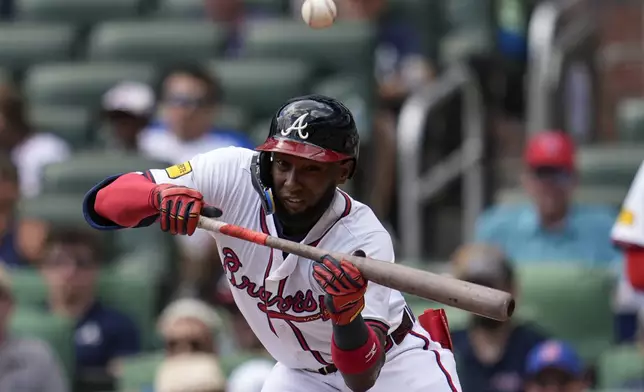 Atlanta Braves'Jurickson Profar (7) bunts into the glove of New York Yankees second baseman Jorbit Vivas (90) in the third inning of a baseball game, Sunday, July 20, 2025, in Atlanta. (AP Photo/Mike Stewart)