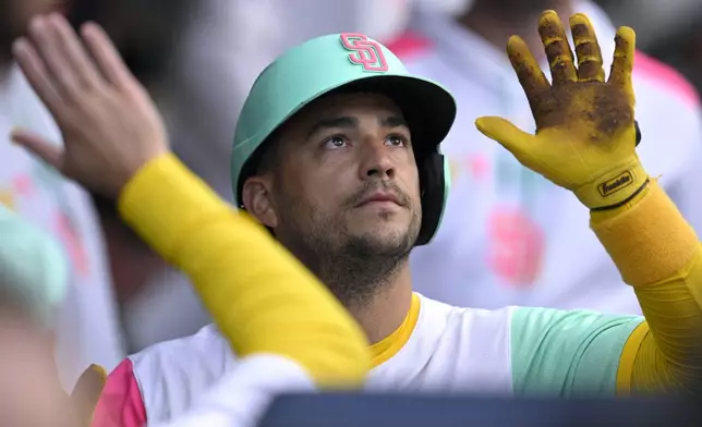 San Diego Padres' Jose Iglesias is congratulated in the dugout after scoring on a single by Fernando Tatis Jr. during the second inning of a baseball game against the Philadelphia Phillies, Friday, July 11, 2025, in San Diego. (AP Photo/Orlando Ramirez)