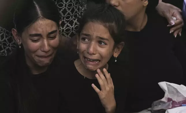 The family of Israeli Defense Force Staff Sgt. Noam Aharon Musgadian, who was killed in action in the Gaza Strip, weeps at his grave during his funeral at Mt. Herzl Military Cemetery in Jerusalem, Tuesday, July 8, 2025. (AP Photo/Maya Alleruzzo)