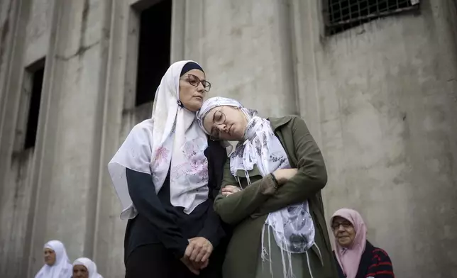 Family members wait for the arrival of seven coffins, containing remains of newly-identified victims of the 1995 Srebrenica genocide, in Potocari, Bosnia, Wednesday, July 9, 2025. (AP Photo/Armin Durgut)