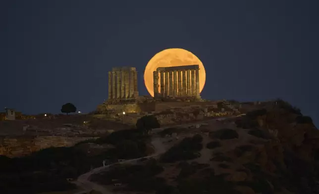 The July full moon, or "Buck Moon," shines over Greece's 2,500-year-old Temple of Poseidon at Cape Sounio, about 70 kilometers (45 miles) south of Athens, Greece, Thursday, July 10, 2025. (AP Photo/Petros Giannakouris)