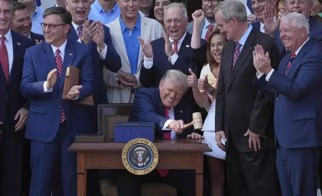 President Donald Trump pounds a gavel presented to him by House Speaker Mike Johnson after he signed his signature bill of tax breaks and spending cuts at the White House, Friday, July 4, 2025, in Washington. (AP Photo/Evan Vucci)