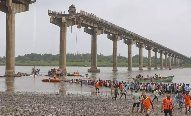 Rescuers and residents look for survivors after several vehicles fell into a river following the collapse of a portion of a bridge in Mujpur, near Vadodara in the Indian state of Gujarat, Wednesday, July 9, 2025. (AP Photo)