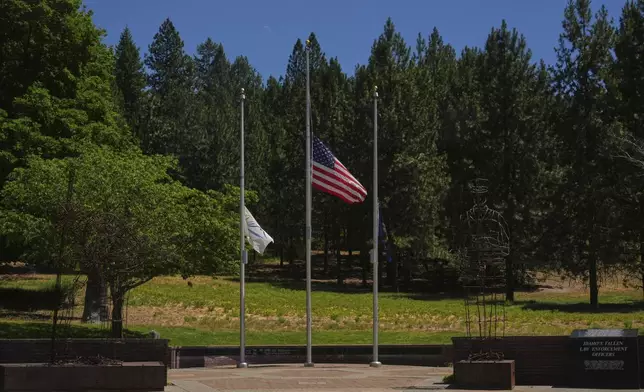 Flags are seen at half-mast at Fallen Heroes Plaza at Cherry Hill Park near the scene the day after a shooter ambushed and killed multiple firefighters responding to a wildfire at Canfield Mountain Monday, June 30, 2025, in Coeur D'Alene, Idaho. (AP Photo/Lindsey Wasson)