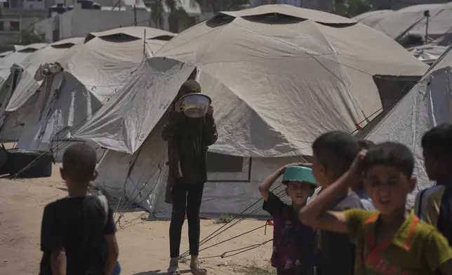 Displaced Palestinians wait for donated food at a community kitchen in Gaza City, northern Gaza Strip, Tuesday, July 22, 2025. (AP Photo/Jehad Alshrafi)