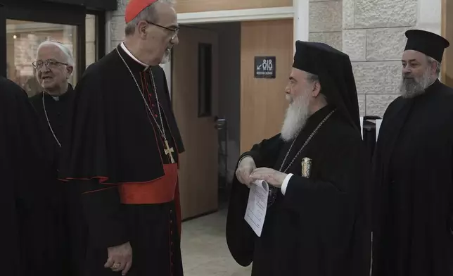 Latin Patriarch Pierbattista Pizzaballa, left, and Greek Orthodox Patriarch Theophilos III greet each other before attending a press conference following their visit to the Gaza Strip, in Jerusalem, Tuesday, July 22, 2025. (AP Photo/Mahmoud Illean)