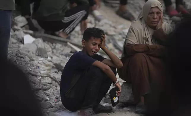 Palestinians mourn during the funeral of people who were killed while trying to reach aid trucks entering northern Gaza through the Zikim crossing with Israel, at Shifa Hospital, in Gaza City, Saturday, July 26, 2025. (AP Photo/Abdel Kareem Hana)