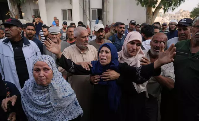 Marwa Barakat, center, mourns during the funeral of her son Fahd Abu Hajeb, 36, who was killed while trying to reach aid trucks entering northern Gaza through the Zikim crossing with Israel, at Shifa Hospital, in Gaza City, Saturday, July 26, 2025. (AP Photo/Abdel Kareem Hana)