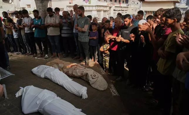 Palestinians pray over the bodies of their relatives who were killed in an Israeli airstrike in Gaza Strip, during their funeral outside the morgue of Shifa Hospital, in Gaza City, Saturday, July 26, 2025. (AP Photo/Abdel Kareem Hana)