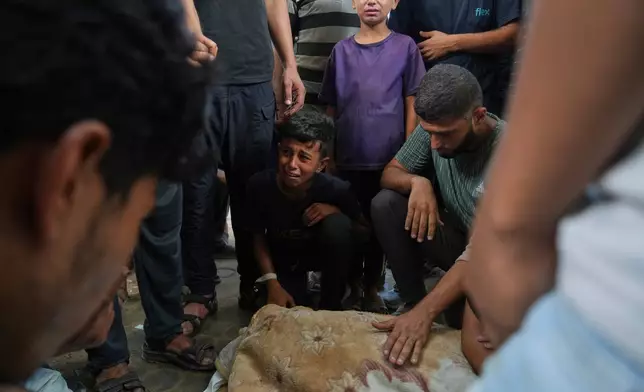 Abdul Karim Foura, center, mourns over the body of his uncle, Mohammed Foura, who was killed in an Israeli airstrike in Gaza Strip, outside the morgue of the Shifa Hospital, in Gaza City, Saturday, July 26, 2025. (AP Photo/Abdel Kareem Hana)