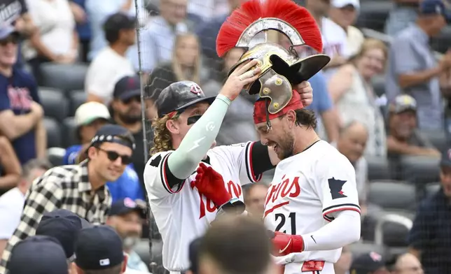 Minnesota Twins' DaShawn Keirsey, right, gets a home-run helmet placed on his head by Harrison Bader after hitting a two-run home run against the Boston Red Sox during the third inning of a baseball game Monday, July 28, 2025, in Minneapolis. Minnesota Twins' Christian Vazquez also scored. (AP Photo/Craig Lassig)