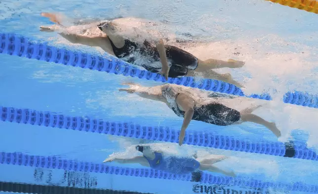 Summer McIntosh of Canada, top, Jamie Perkins of Australia and Maya Werner of Germany compete in the women's 400-meter freestyle final at the World Aquatics Championships in Singapore, Sunday, July 27, 2025. (AP Photo/Lee Jin-man)