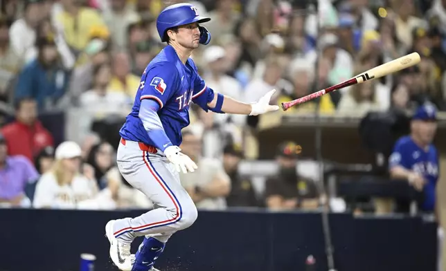 Texas Rangers' Kyle Higashioka (11) hits an RBI single during the eighth inning of a baseball game against the San Diego Padres Saturday, July 5, 2025. (AP Photo/Denis Poroy)