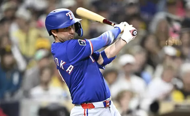 Texas Rangers' Kyle Higashioka (11) hits an RBI single during the eighth inning of a baseball game against the San Diego Padres Saturday, July 5, 2025. (AP Photo/Denis Poroy)