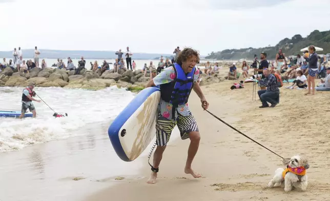Matt Jenkins and Gigi compete at Dog Masters Festival a dog on a paddle board contest near Poole in Dorset, England, Sunday, July 27, 2025. (AP Photo/Kirsty Wigglesworth)