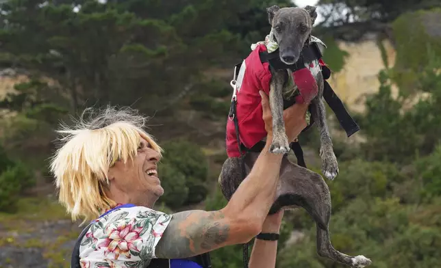 Carl Barnes and Margo celebrate winning thet Dog Masters Festival a dog on a paddle board contest near Poole in Dorset, England, Sunday, July 27, 2025. (AP Photo/Kirsty Wigglesworth)