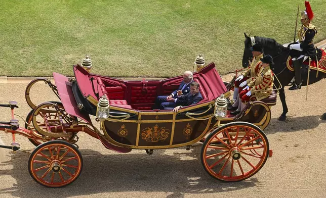 Britain's King Charles III, left, and French President Emmanuel Macron arrive at Windsor Castle in Windsor, England, Tuesday July 8, 2025, on the first day of a three-day state visit to Britain. (Jaimi Joy/Pool via AP)