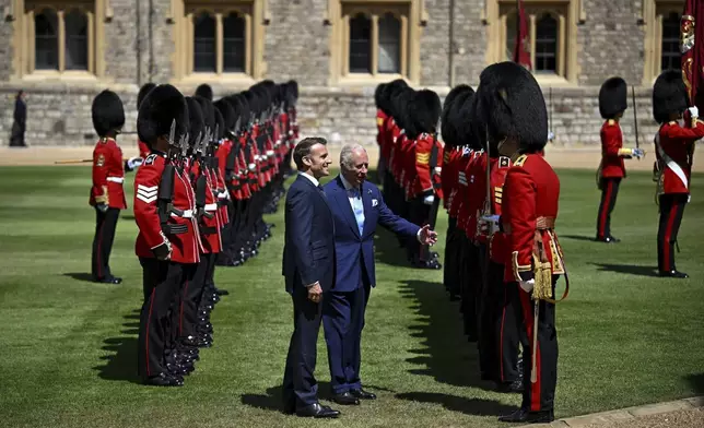Britain's King Charles III, center right, and French President Emmanuel Macron attend a welcome ceremony at Windsor Castle, in Windsor, England, Tuesday July 8, 2025, on the first day of a three-day state visit to Britain. (Dylan Martinez/Pool via AP)