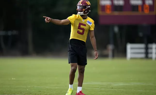 Washington Commanders quarterback Jayden Daniels (5) gestures during practice at the team's NFL football training camp, Wednesday, July 23, 2025, in Ashburn, Va. (AP Photo/Mark Schiefelbein)