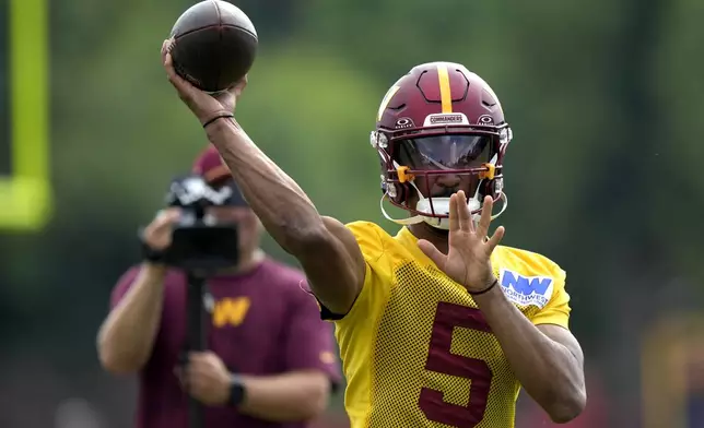 Washington Commanders quarterback Jayden Daniels (5) throws during practice at the team's NFL football training camp, Wednesday, July 23, 2025, in Ashburn, Va. (AP Photo/Mark Schiefelbein)