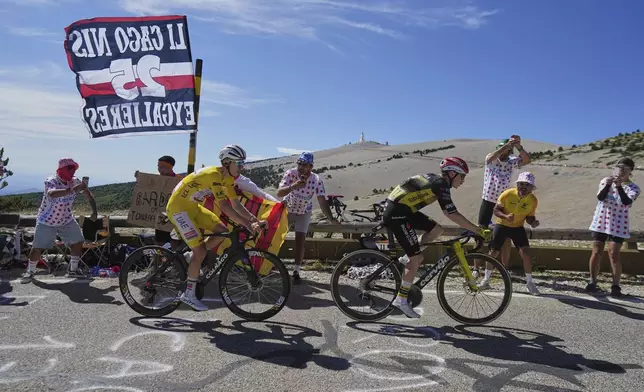 Slovenia's Tadej Pogacar, wearing the overall leader's yellow jersey, follows Denmark's Jonas Vingegaard as they climb to the summit of Mont Ventoux, rear, during the sixteenth stage of the Tour de France cycling race over 171.5 kilometers (106.6 miles) with start in Montpellier and finish on the Mont Ventoux, France, Tuesday, July 22, 2025. (AP Photo/Thibault Camus)