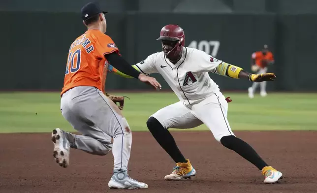 Arizona Diamondbacks' Geraldo Perdomo gets tagged out by Houston Astros third baseman Shay Whitcomb (10) on a ball hit by Ketel Marte in the fifth inning during a baseball game, Wednesday, July 23, 2025, in Phoenix. (AP Photo/Rick Scuteri)