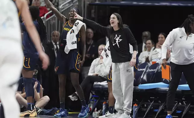 Indiana Fever's Caitlin Clark, center front, cheers during the second half of a WNBA basketball game against the Las Vegas Aces, Thursday, July 3, 2025, in Indianapolis. (AP Photo/Michael Conroy)