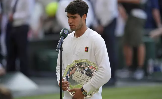 Carlos Alcaraz of Spain is interviewed holding his runners-up trophy after losing to Italy's Jannik Sinner in the men's singles final at the Wimbledon Tennis Championships in London, Sunday, July 13, 2025. (AP Photo/Kin Cheung)